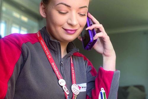 A British Red Cross volunteer on the phone.